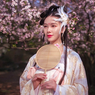 粉色桃花拂面带团扇女生头像，唯美古风真人头